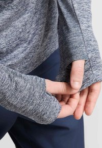 Donkergrijze longsleeve shirt met een gemarmerde textuur en duimhole in de manchetten. Het ontwerp heeft een ontspannen pasvorm en een ronde hals.