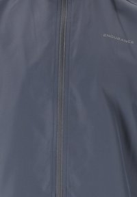 Laivastonsininen takki, joka on valmistettu kevyestä kankaasta ja siinä on keskellä vetoketju sekä huomaamaton brändäys. Sujuva tekstuuri ja minimalistinen muotoilu.