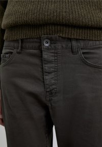 Mørkegrå bomuldsbukser med lige ben, der har en forreste knap, bæltestropper og subtile syningsdetaljer.