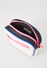 Custodia nera e bianca con cerniere rosa e blu, lato in tessuto morbido e design elegante. Presenta due scomparti per l'organizzazione.