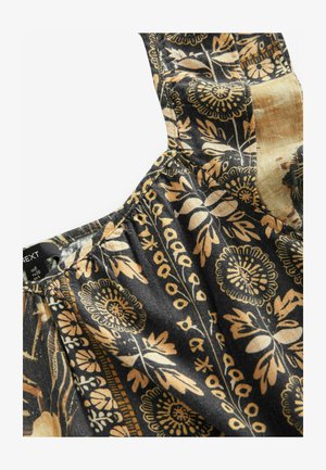 Tessuto a motivo floreale in nero e oro, con spalline e una texture arricciata, caratterizzato da disegni intricati di fiori e foglie.