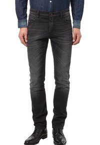 Szare dżinsy z denimu o dopasowanym kroju, z pięcioma kieszeniami i subtelnym efektem przecierania. Noszone z dżinsową koszulą i czarnymi eleganckimi butami.