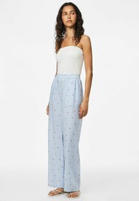 Pantalons large à rayures bleu clair avec de petits motifs floraux rouges. Taille élastique, fabriqués dans un tissu doux et respirant.