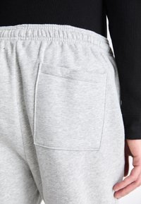 Grijze sweatpants met een elastische tailleband, voorzien van een enkele achterzak. Gemaakt van een zachte katoenmix, met een gladde textuur.