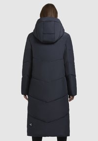 Dark navy long puffer coat with a chevron quilted design, an attached hood, and side pockets. Features a small logo near the hem.