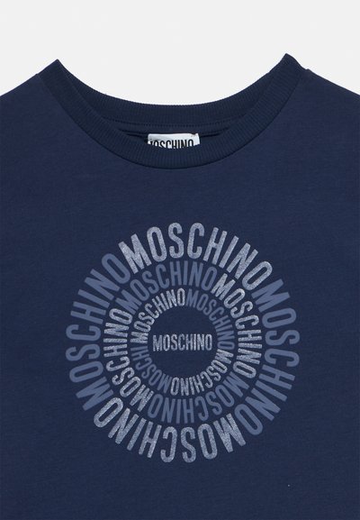 Chemise bleu marine avec un motif circulaire du mot « Moschino » dans différentes nuances de bleu, centré sous le col.