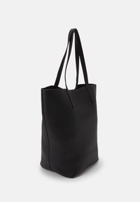Sac cabas en cuir noir avec des poignées longues et plates. Texture lisse, ouverture supérieure et design minimaliste sans ferrures ni ornements visibles.