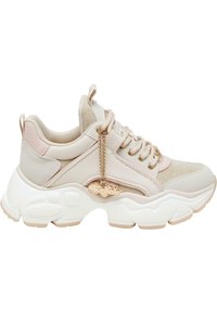 Bežid sneaker tekstureeritud kangast ja siledast nahast aktsentidega. Omab suuremat valgest kummist talla ja kuldset kettlogo detaili.