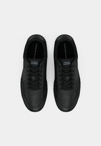 Sorte lædersneakers med en glat overflade, der har et strømlinet design, snørebåndslukning og mærket indersål.