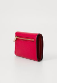 Portafoglio in pelle fucsia con tasca con zip, texture liscia e cuciture a contrasto. Forma rettangolare compatta, con hardware dorato visibile.