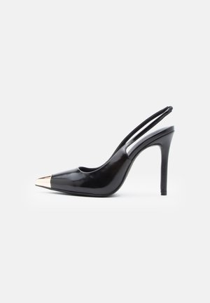 Black patent leather slingback shoe with a pointed toe and metallic gold cap. Features a slim heel and cutout sides.