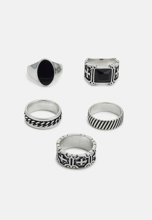 Set of five rings: one silver signet ring with black stone, four metallic bands with various designs, including braided and striped patterns.