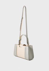 Gestructureerde handtas met een beige middenstuk en zilveren zijkanten, dubbele handgrepen en een lange verstelbare schouderband. Gelaagde leren afwerking.