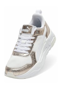 Weiße Sneakers mit metallisch goldenen Akzenten, ausgestattet mit einem strukturierten Mesh-Obermaterial, gepolstertem Kragen und dicker Gummisohle. Puma-Logo auf der Zunge.