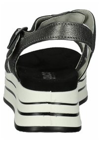 Black and silver sandal with a textured metallic strap, adjustable buckle, and a contrasting white sole with black stripes.