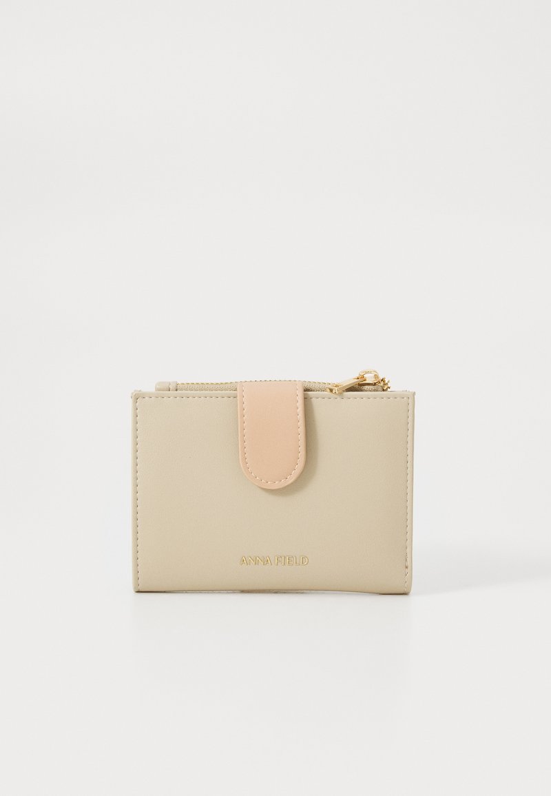 Beige falsk skinnlommebok med rosa trykknapp og gullfarge detaljer. Har en jevn tekstur og preget merkevare på fronten.