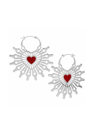 Silver hoop earrings with heart-shaped centers, featuring red accents. Intricate cut-out design radiates from the hearts, creating a sunburst effect.