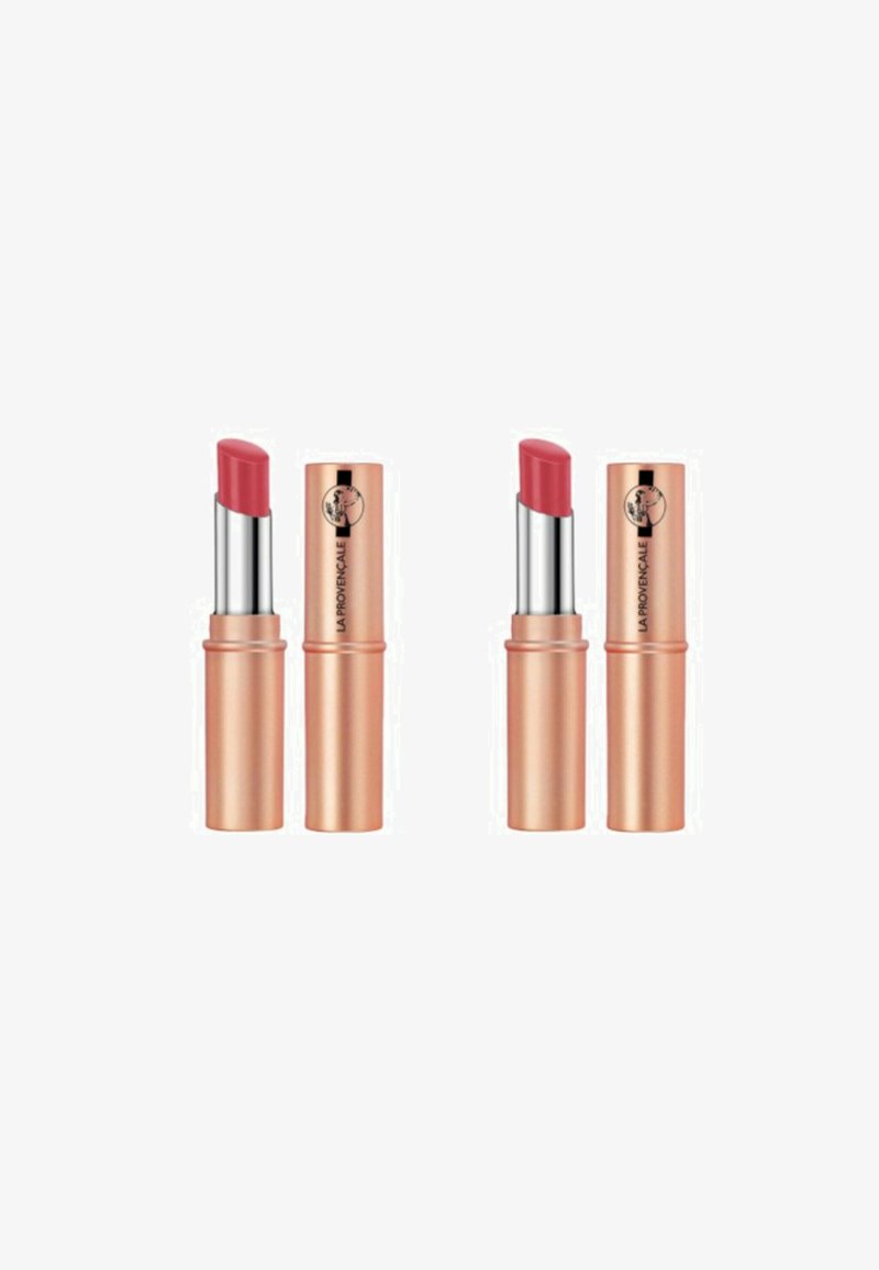 Deux rouges à lèvres dans des étuis cylindriques en or rose avec des accents argentés. Chacun a une pointe lisse et arrondie dans une teinte rose doux.