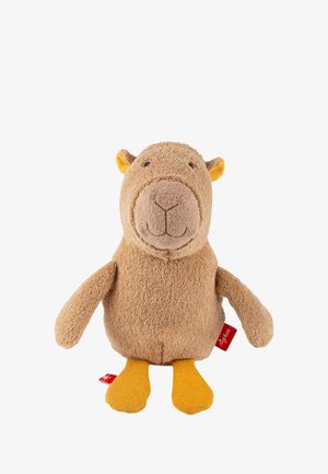 Morbido peluche marrone simile a un orso con muso rotondo, piccole orecchie e piedi in tessuto giallo, in piedi su uno sfondo bianco.