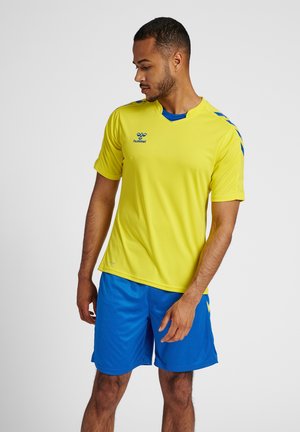 Gul sportsjersey med blå accenter, korte ærmer, v-hals design og "hummel" logo. Kombineret med blå shorts. Glat stofstruktur.