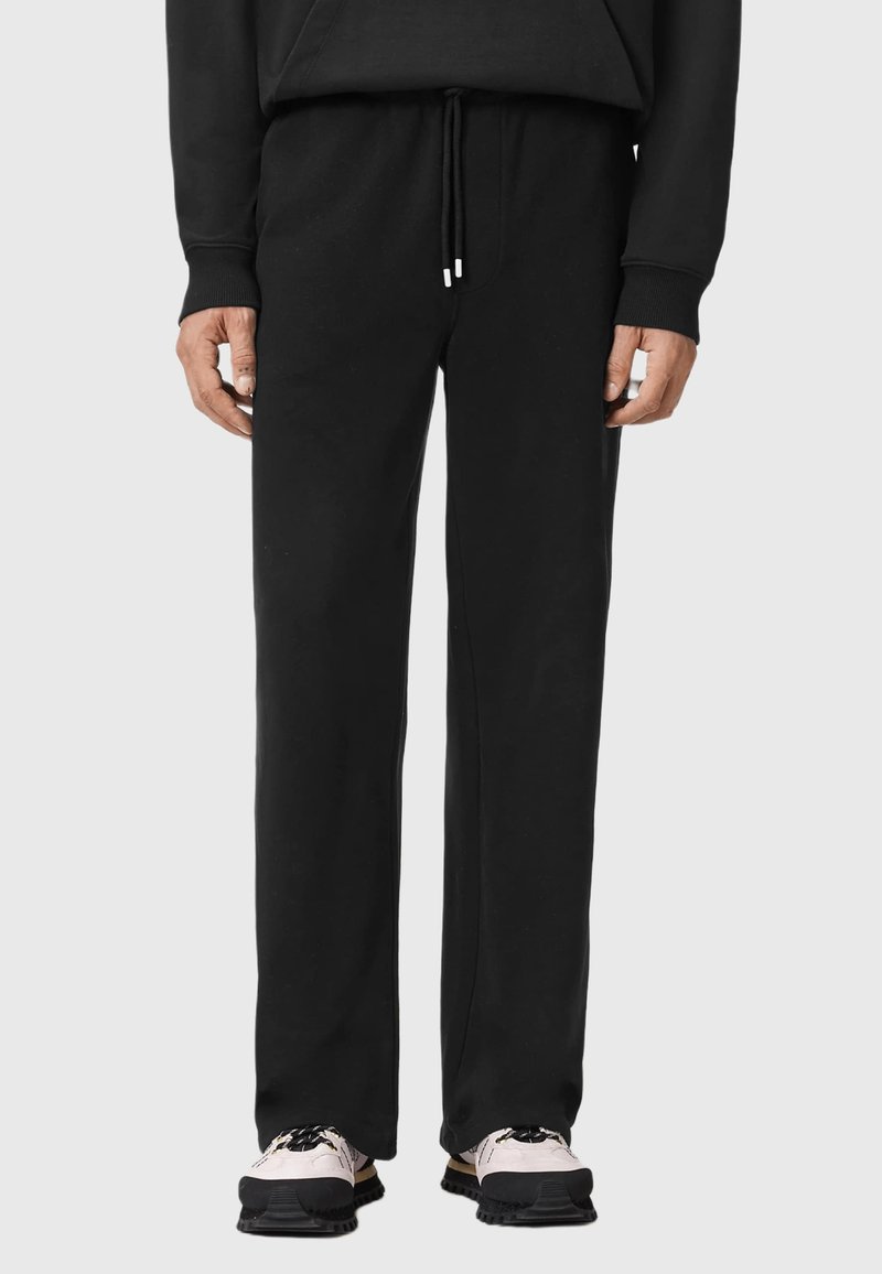 Czarne dresy o luźnym kroju, z regulowanym sznurkiem w pasie i miękką teksturą materiału. Charakteryzują się minimalistycznym designem bez wzorów czy akcentów.