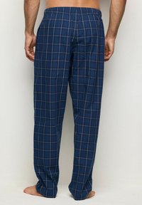 Marineblauwe geruite loungebroek van lichtgewicht stof met een elastische tailleband, voorzien van zakken en een losse pasvorm voor comfort.