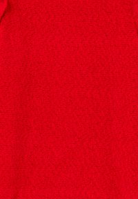 Tessuto rosso testurizzato con un motivo denso e intrecciato. Il materiale appare morbido e caldo, adatto per capi di abbigliamento esterno o maglieria.