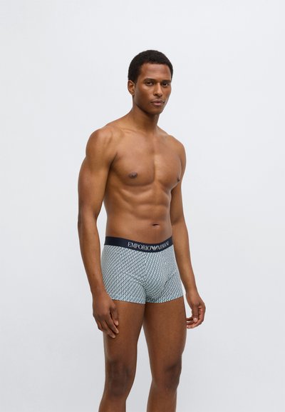 Μπόξερ εσώρουχα με γεωμετρικό σχέδιο, διαθέτουν ναυτικό μπλε ζώνη μέσης με το λογότυπο "Emporio Armani". Κατασκευασμένα από απαλό, ελαστικό ύφασμα, με εφαρμοστή σχεδίαση.
