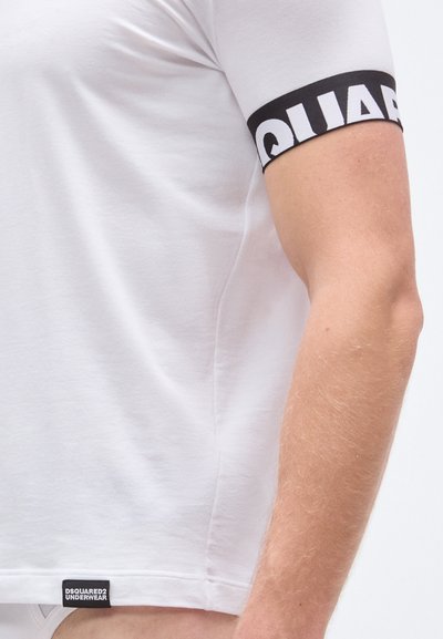 Hvid tætsiddende T-shirt med et sort bånd på ærmet med teksten "DSQUARED2" i hvid. Blødt bomuldsstof med en logomærkat i kanten forneden.