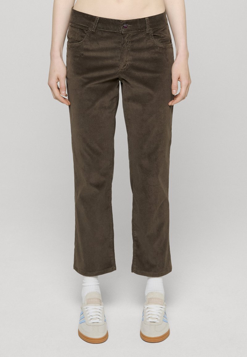 Brune kordfløyelsbukser med rett ben, med frontlommer og en subtil ribbestruktur. Enkel midje med knappelukking.