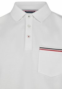 Witte polo met een gestructureerde stof. Voorzien van een kraag, een knoopsluiting met drie knopen en een borstzak met accentstrepen in rood, wit en blauw.