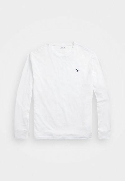 Bela dolgih rokavov majica iz bombaža, s krojnim ovratnikom in majhnim mornarsko modrim logotipom polo na levi strani prsnega dela. Gladka tekstura.