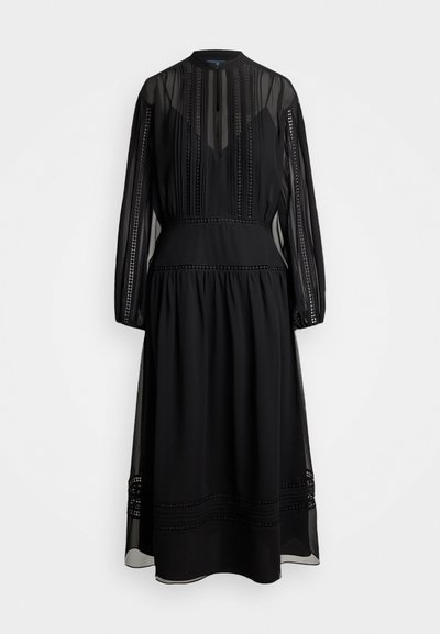 Abito nero con lunghe maniche trasparenti, colletto alto e motivi decorativi di cucitura lungo il corpetto e l'orlo. Tessuto leggero, design fluido.