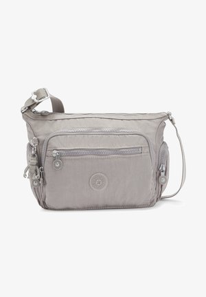 Light gray crossbody bag with multiple zippered pockets, fabric material, adjustable strap, and a decorative monkey keychain.
