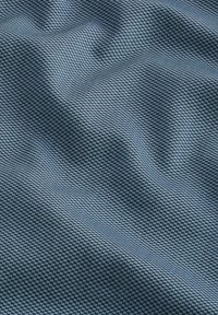 Țesătură texturată de culoare albastru închis, cu un model geometric subtil. Finisaj neted cu o ușoară strălucire, efect de pliere vizibil pe suprafață.