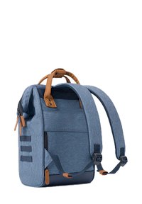 Blauer Stoffrucksack mit beigefarbenen Lederakzenten, strukturierter Form, verstellbaren gepolsterten Trägern und mehreren Fächern mit Reißverschluss.