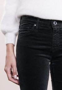 Černé džíny skinny s hladkou strukturou, mid-rise pasem, standardním designem se pěti kapsami a akcenty ve stříbrné barvě.