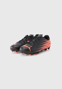 Černé fotbalové kopačky s hladkou texturou, s jasně oranžovými akcenty a pruhy, šněrovací design a formované kolíky na podrážce.