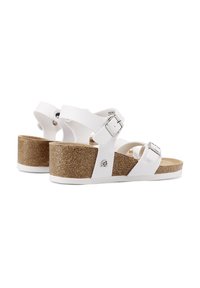 Sandali platform bianchi con più cinturini, dettagli in fibbia e tacco in sughero testurizzato. Materiale superiore liscio e soletta imbottita.