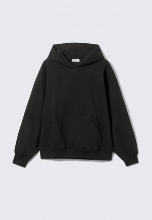 Must kapuutsiga dressipluus, valmistatud pehmest kangast. Esiküljel taskuga ja soonikkoes mansetid. Lõdvestunud istuvus ja lihtsa, minimalistliku disainiga.