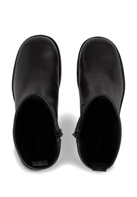 Stivaletti neri in pelle con una finitura liscia, punta rotonda, chiusura con zip e suola testurizzata. Design minimalista senza motivi visibili.