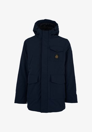Parka blu navy realizzata in materiale resistente all'acqua, con cappuccio, molteplici tasche frontali e un'etichetta a patch testurizzata sul petto.