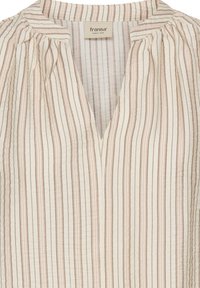 Csíkos blúz V-nyakkivágással, könnyű anyagból készült. Krém, rózsaszín és barna árnyalatú függőleges csíkokkal. Vállnál ráncolt részletekkel.