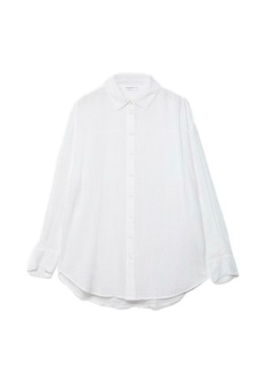 Camicia bianca a maniche lunghe con bottoni, colletto e orlo curvo, mostrata distesa su uno sfondo bianco.