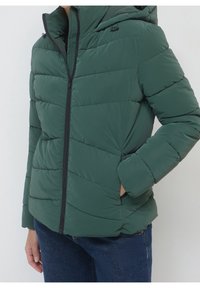 Giacca a vento verde con cappuccio, design trapuntato, chiusura a zip e tasche laterali. Realizzata in materiale leggero e resistente all'acqua.