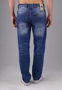 Blue denim jeans with a straight cut, faded design, five-pocket styling, and a leather patch on the back waistband.
