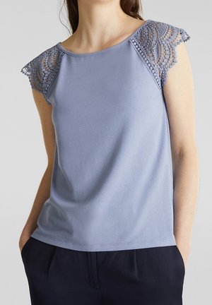 Lichtblauw mouwloos topje met kantaccenten op de schouders. Zachte stof, ronde halslijn en een ontspannen pasvorm. Schone zoom en subtiele glans.