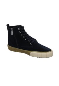 Baskets montantes noires avec fermeture éclair latérale, lacets noirs et semelle épaisse en caoutchouc beige avec protège-orteils.
