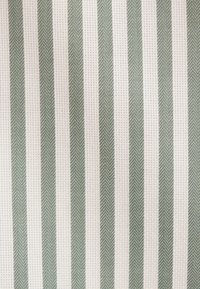 Tessuto in cotone con strisce verticali verdi e bianche, caratterizzato da un sottile motivo a spina di pesce, leggero e con texture.