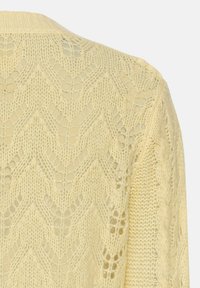 Lace gestrickte Strickjacke in sanftem Gelb, mit einem Zickzackmuster und offenen Maschen. Runder Ausschnitt und detaillierte Zopfmuster-Akzente an den Ärmeln.